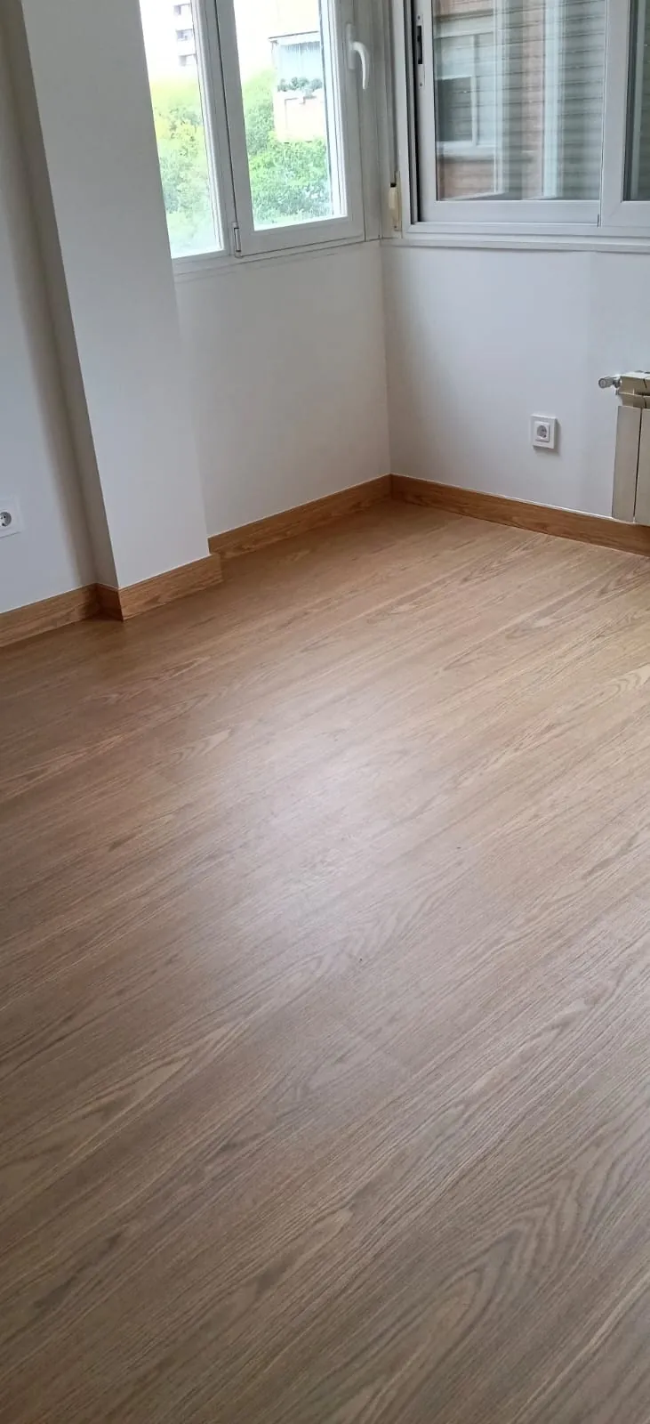 La habitación terminada junto a las ventanas, con el rodapié a juego con el suelo.