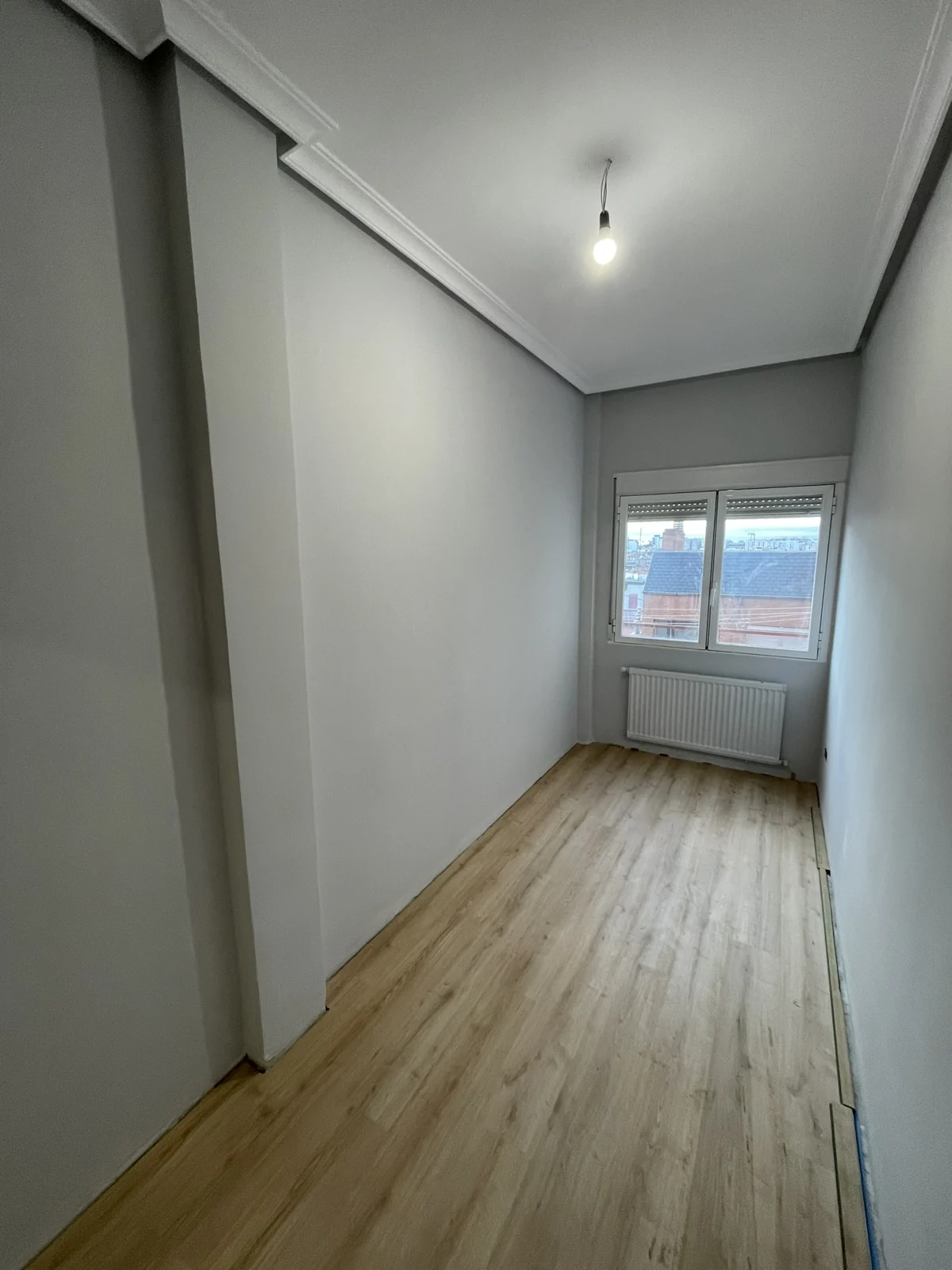 Habitación 2 con el suelo instalado y el rodapié todavía pendiente.