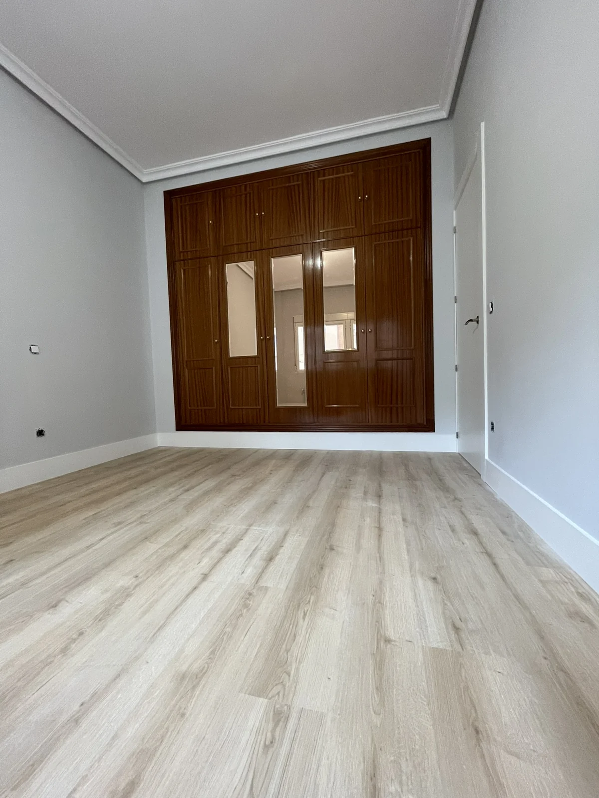 Habitación 3: detalle del acabado roble desde el suelo hacia el armario.